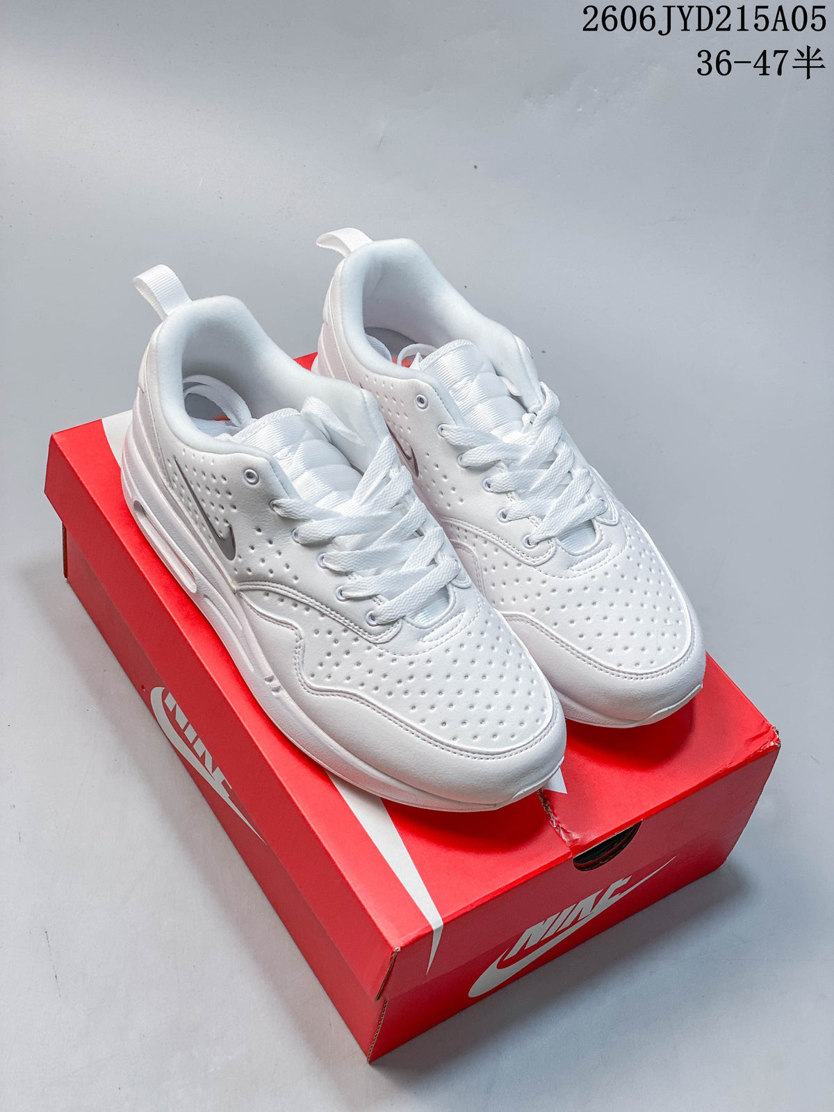 Pair of white Nike Air Max 1 low-top sneakers on a red Nike shoe box