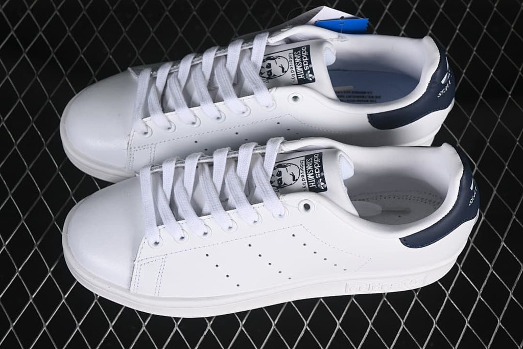 Pair of white Stan Smith sneakers with navy heel tabs.