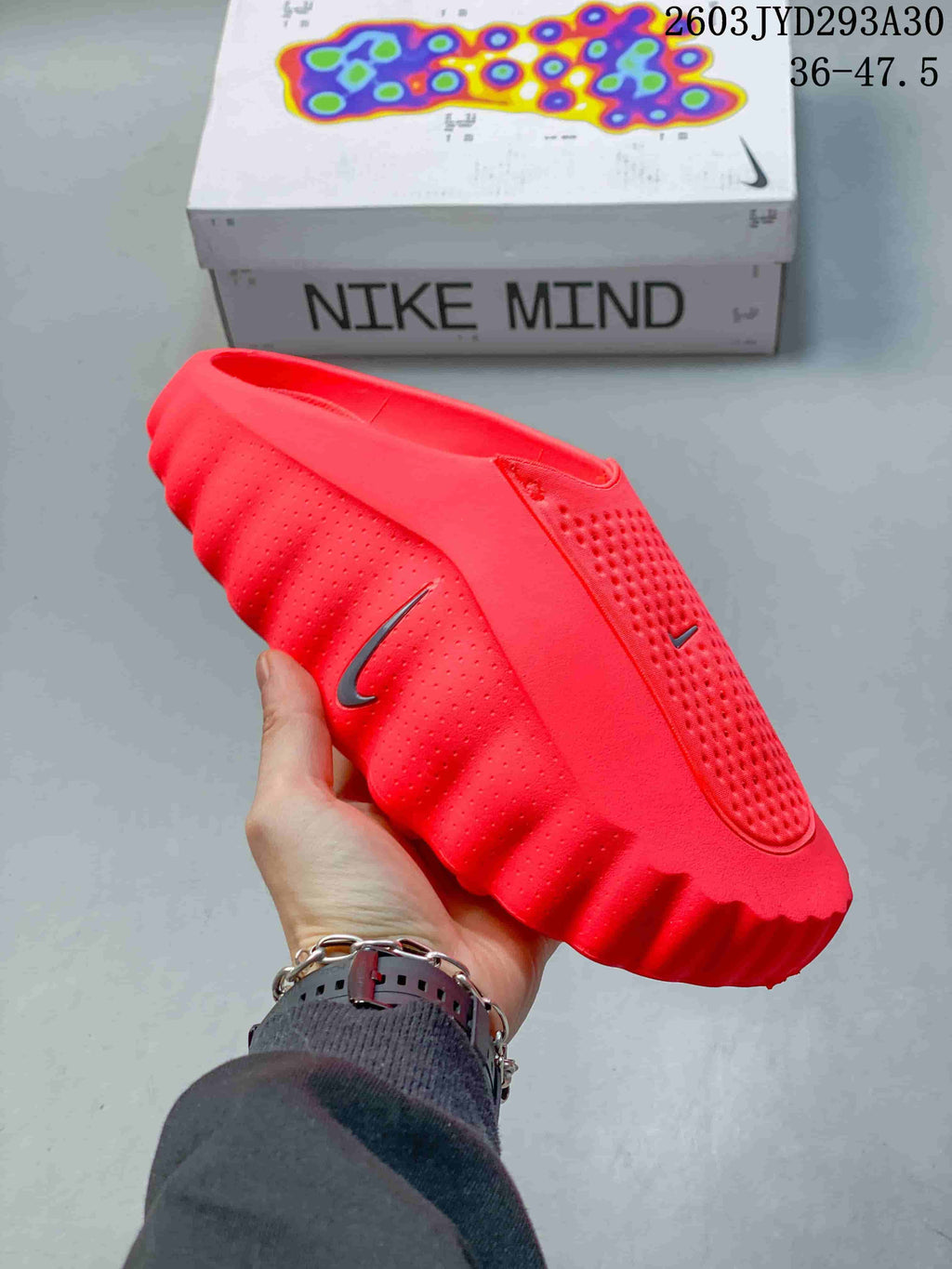 Angled side view of a bright red Nike Mind slide with visible Nike branding and textured sole.