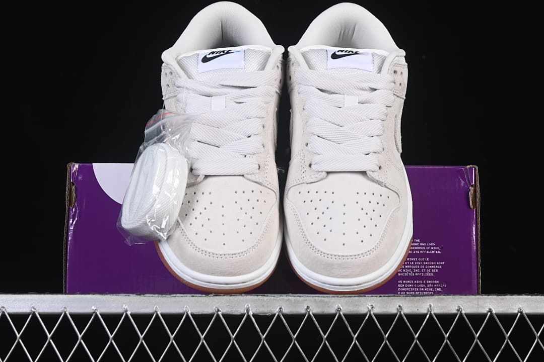 Front view of the pair with an extra set of laces beside the shoes
