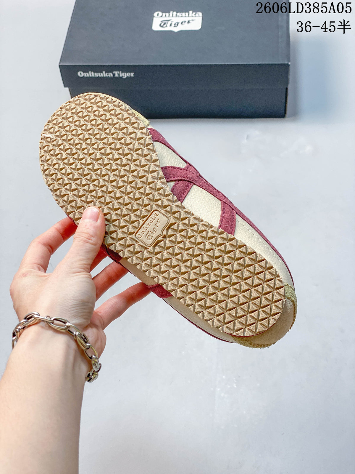 Close-up of the textured outsole and side stripes on a beige and burgundy sneaker