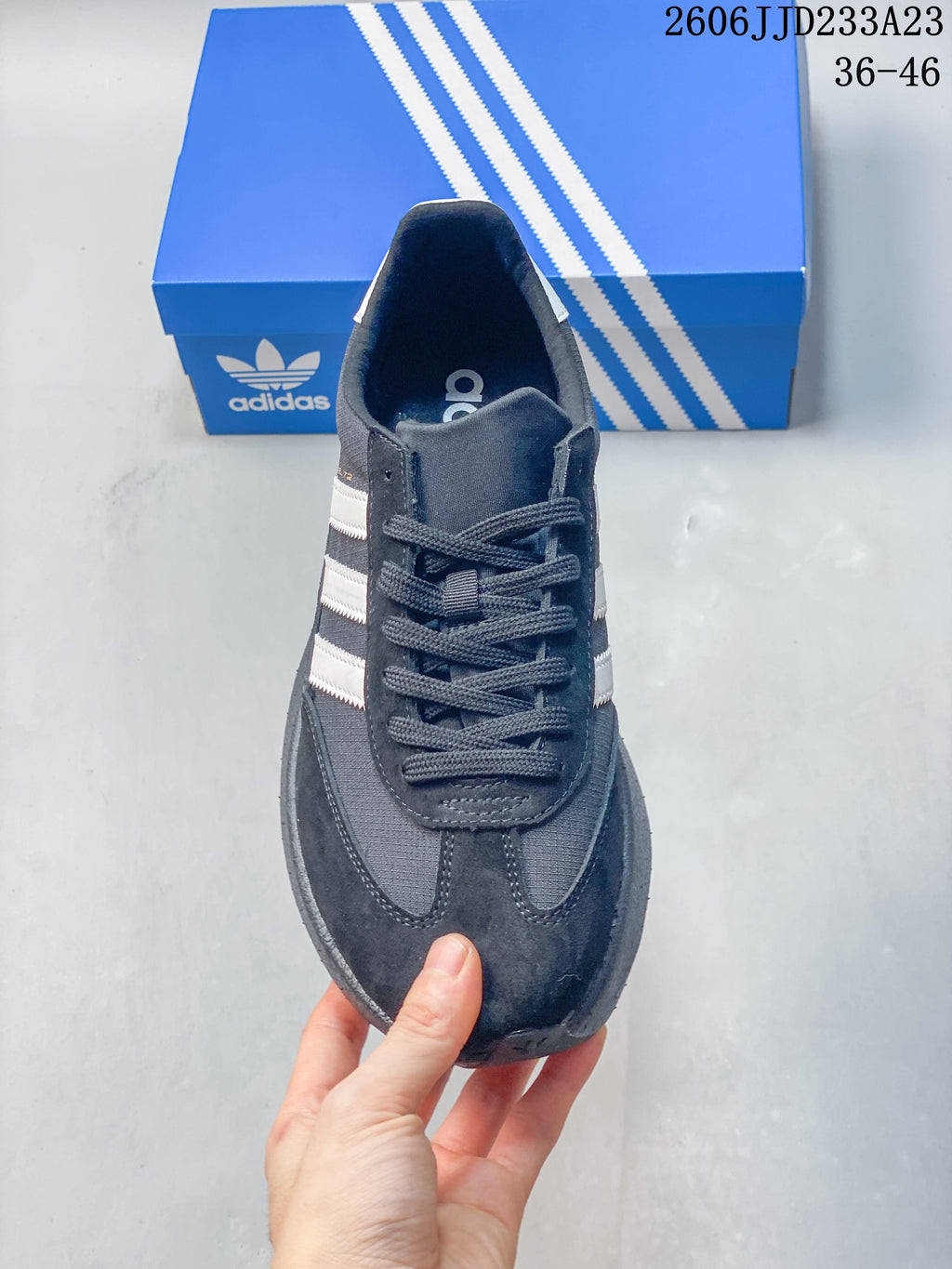 Top view of a lace-up charcoal sneaker with white side stripes