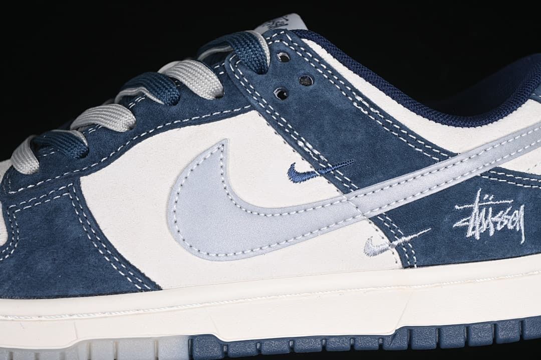 Close-up of navy and white panels, gray Swoosh, and side graphic