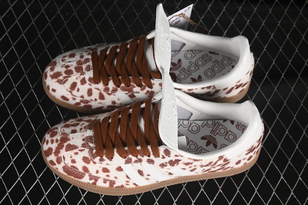 Pair of spotted low-top sneakers with white stripes and brown laces