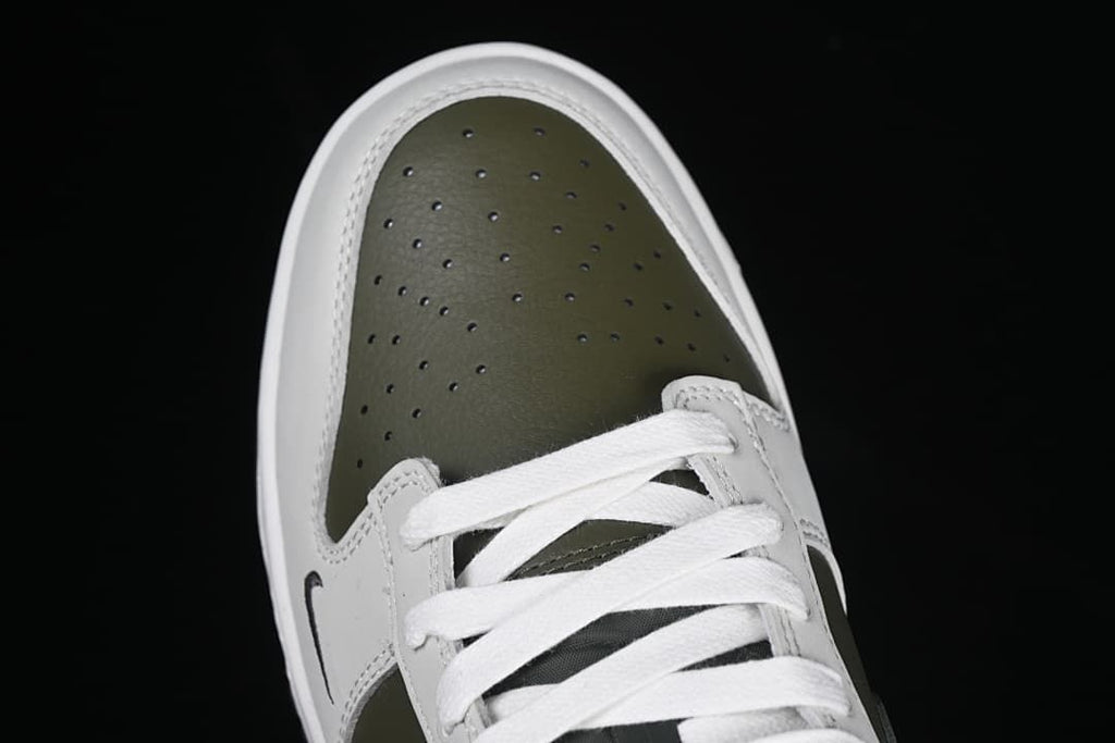 Top-down view of the perforated olive toe and white laces.