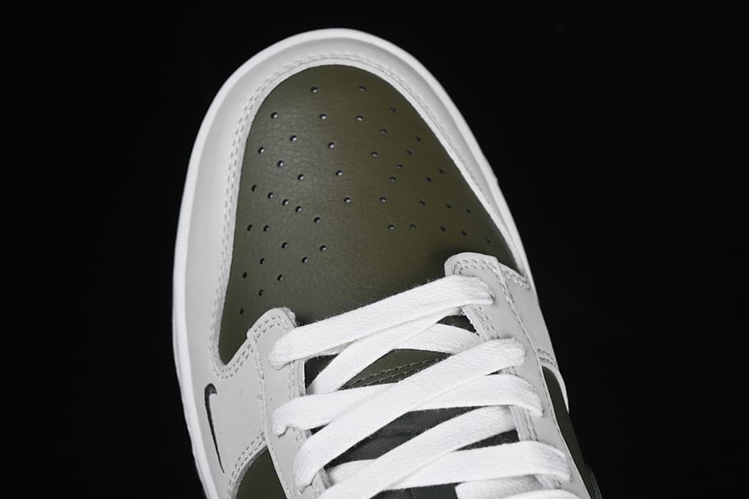 Top-down view of the perforated olive toe and white laces.