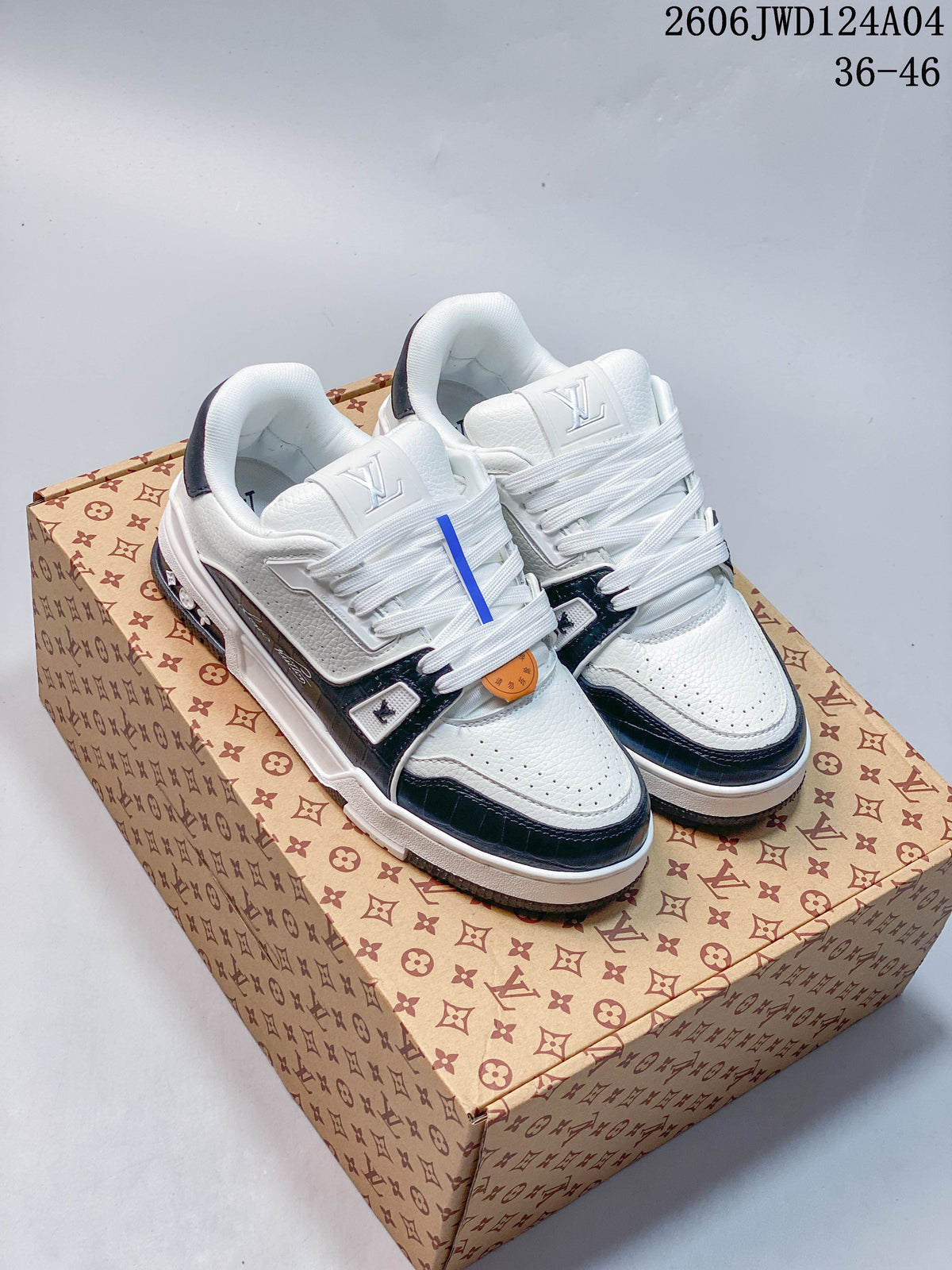White low-top sneakers with dark trim and lace-up closure, photographed on a patterned box.