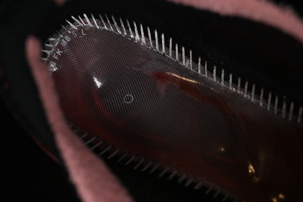Close-up inside the shoe showing the translucent red sole and stitching