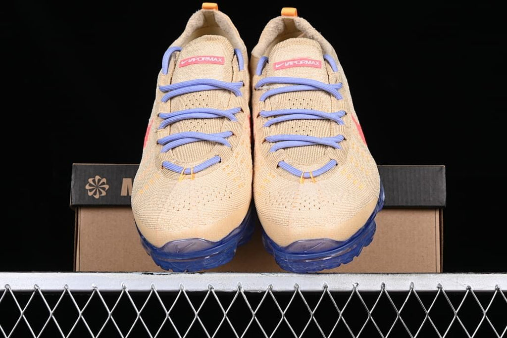 Front view of the pair showing beige knit uppers, lavender laces and blue soles.