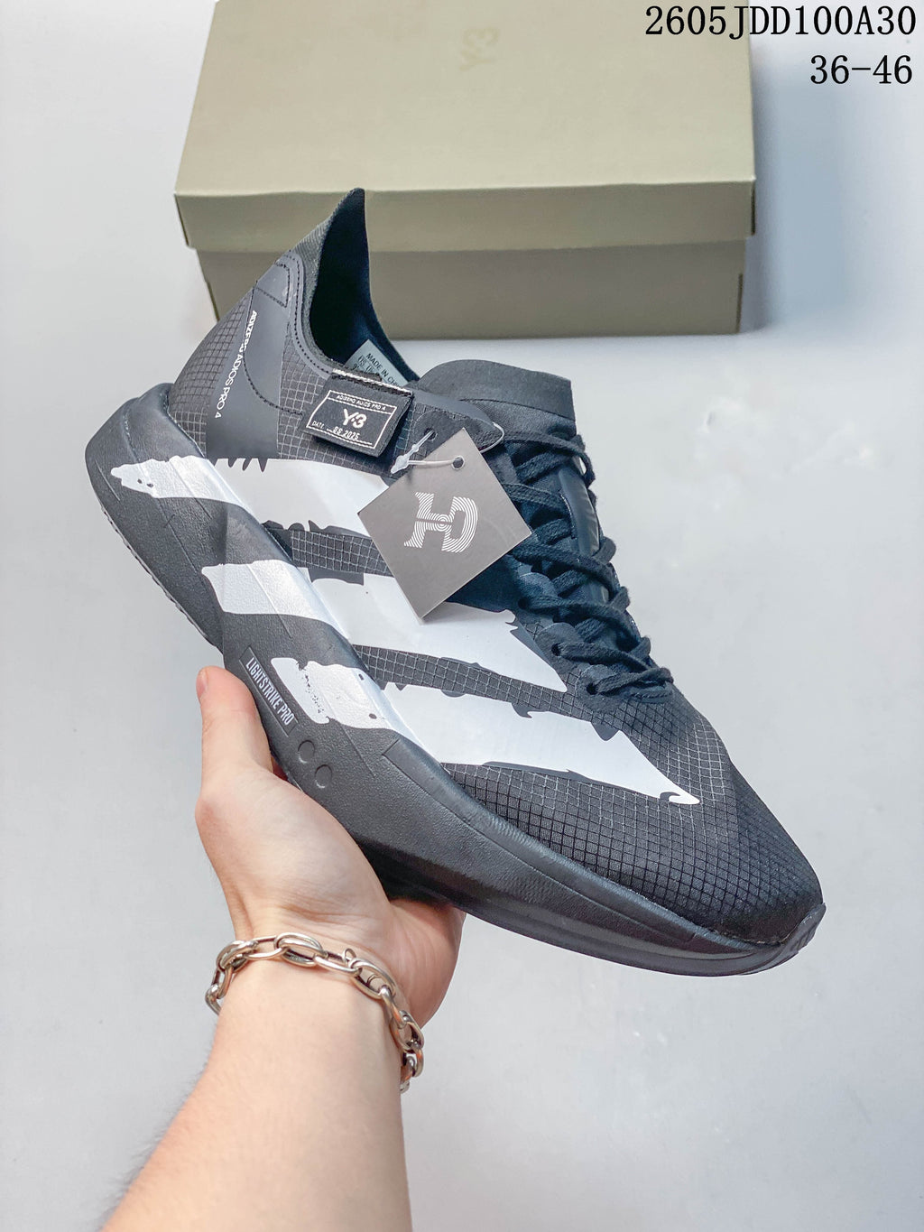 Close side view of a gray and white running shoe with lace-up closure