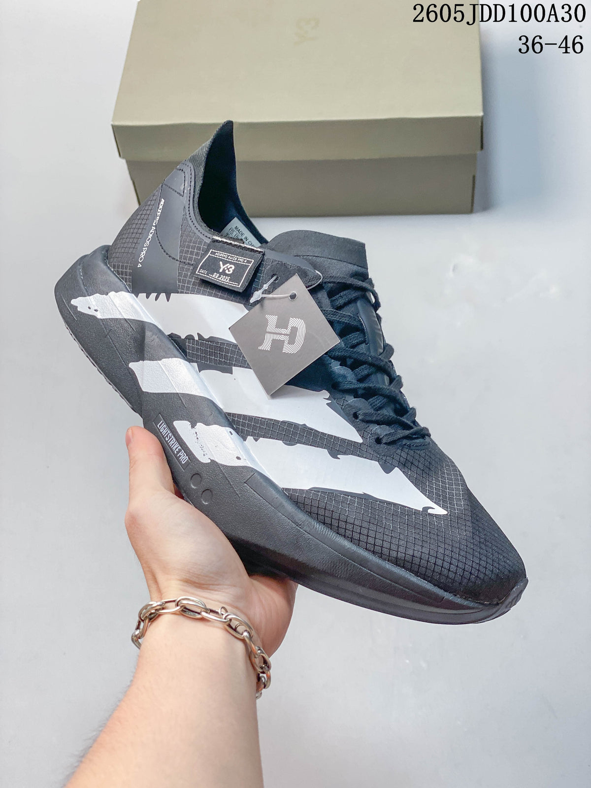 Close side view of a gray and white running shoe with lace-up closure