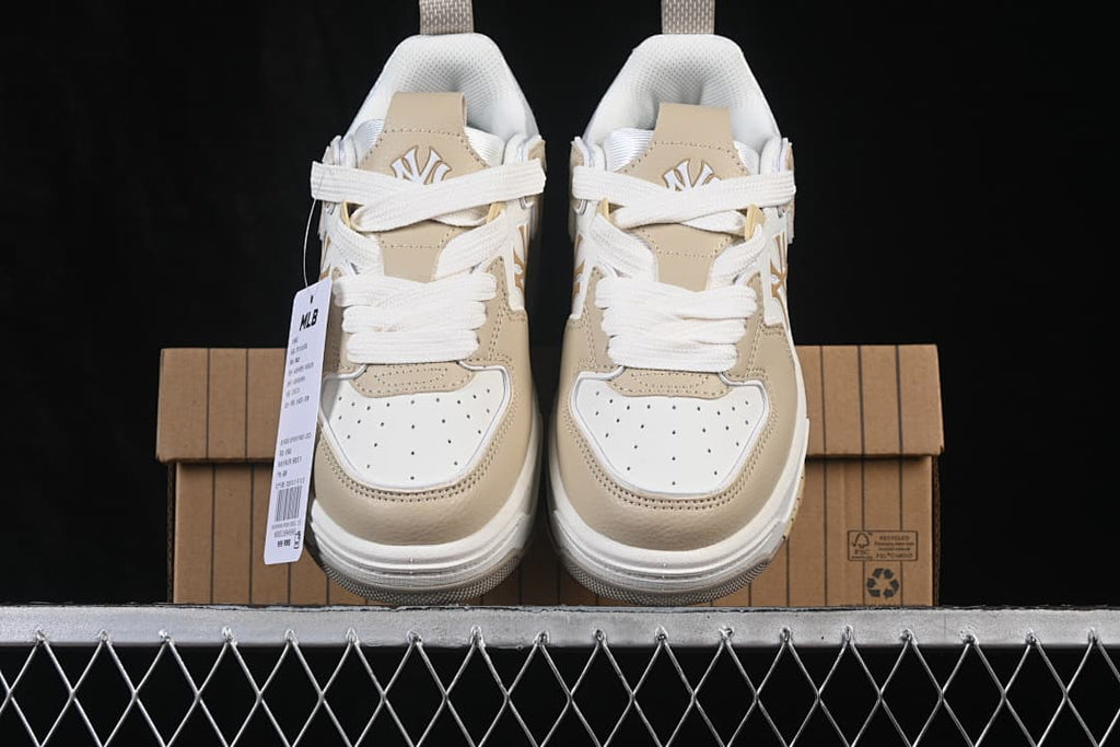 Front view of the pair of beige and white MLB sneakers on the box