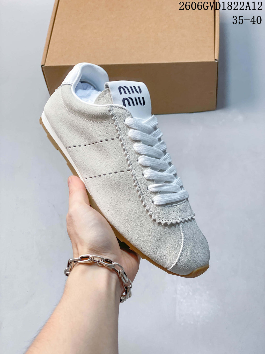 Angled view of the white and light gray sneaker showing its low-top profile and side detailing.