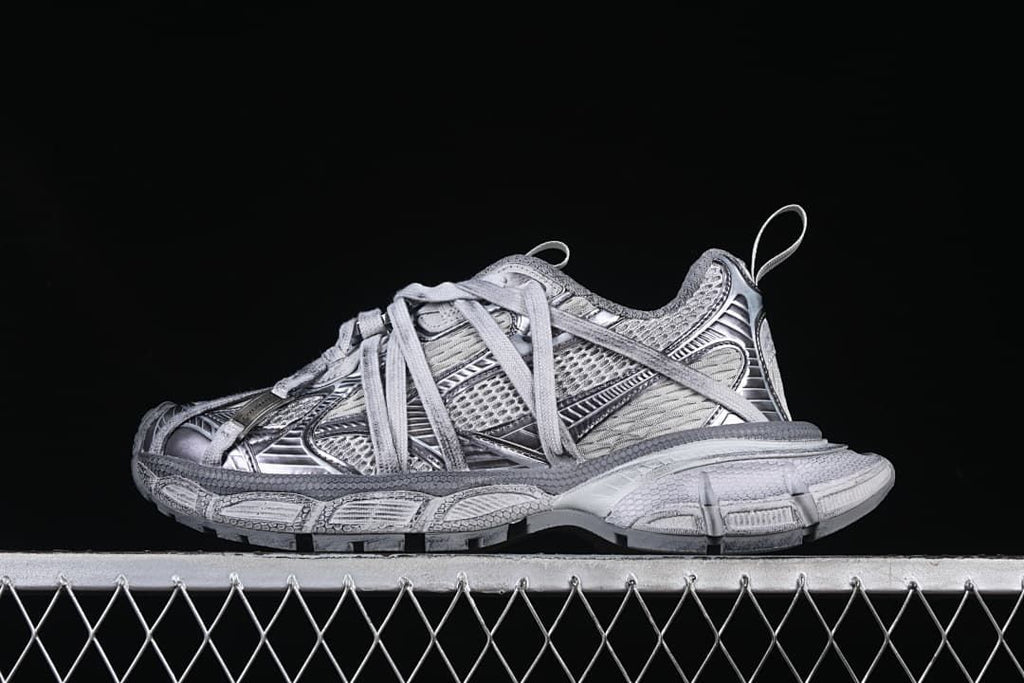 Side view of the grey mix Balenciaga 3XL sneaker against a dark background