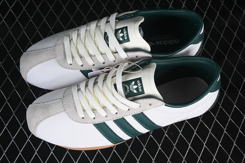 Pair of white and dark green Adidas Tokyo sneakers viewed from above