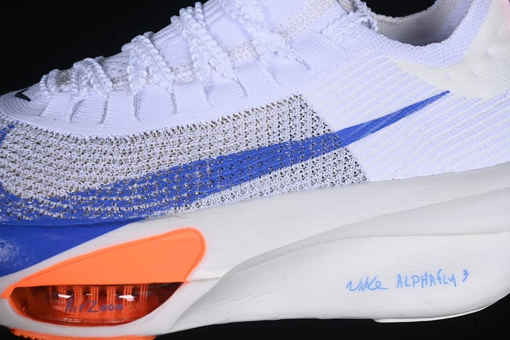 Close-up of the white upper, blue Swoosh and orange forefoot detail.