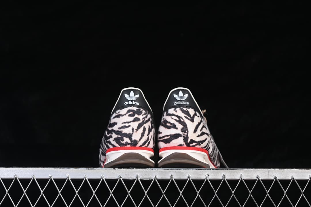 Rear view of both sneakers showing animal-print heels and red midsole accents.