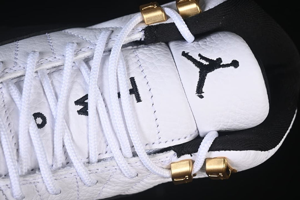 Close-up of the white tongue, black Jumpman logo and gold-tone lace hardware.