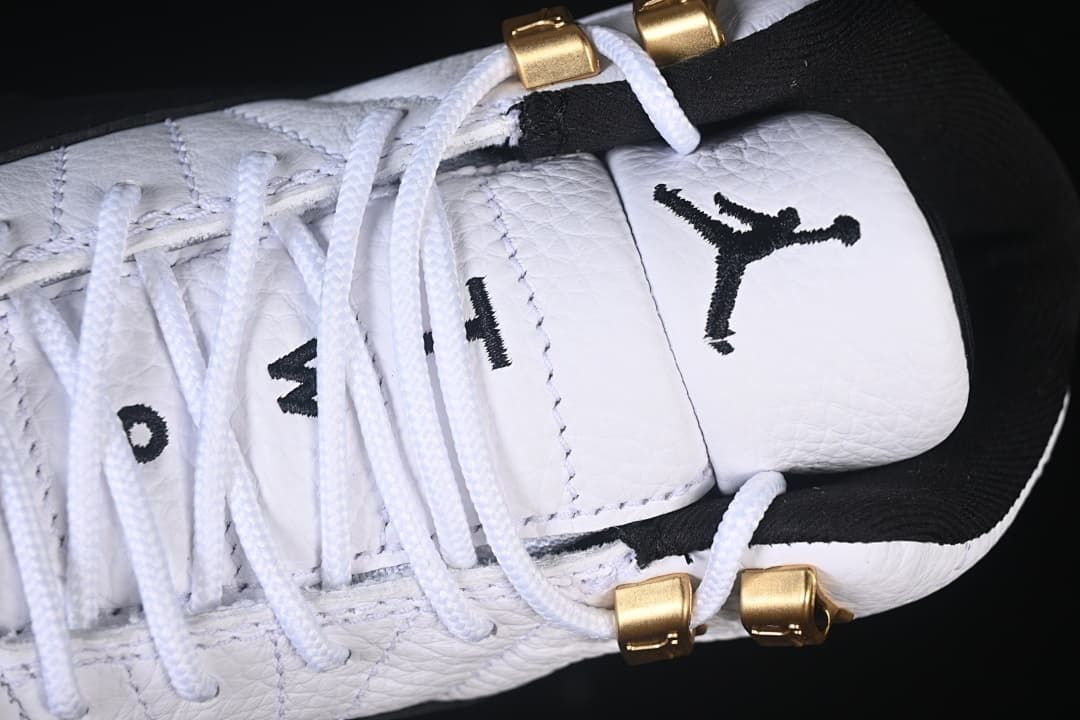 Close-up of the white tongue, black Jumpman logo and gold-tone lace hardware.