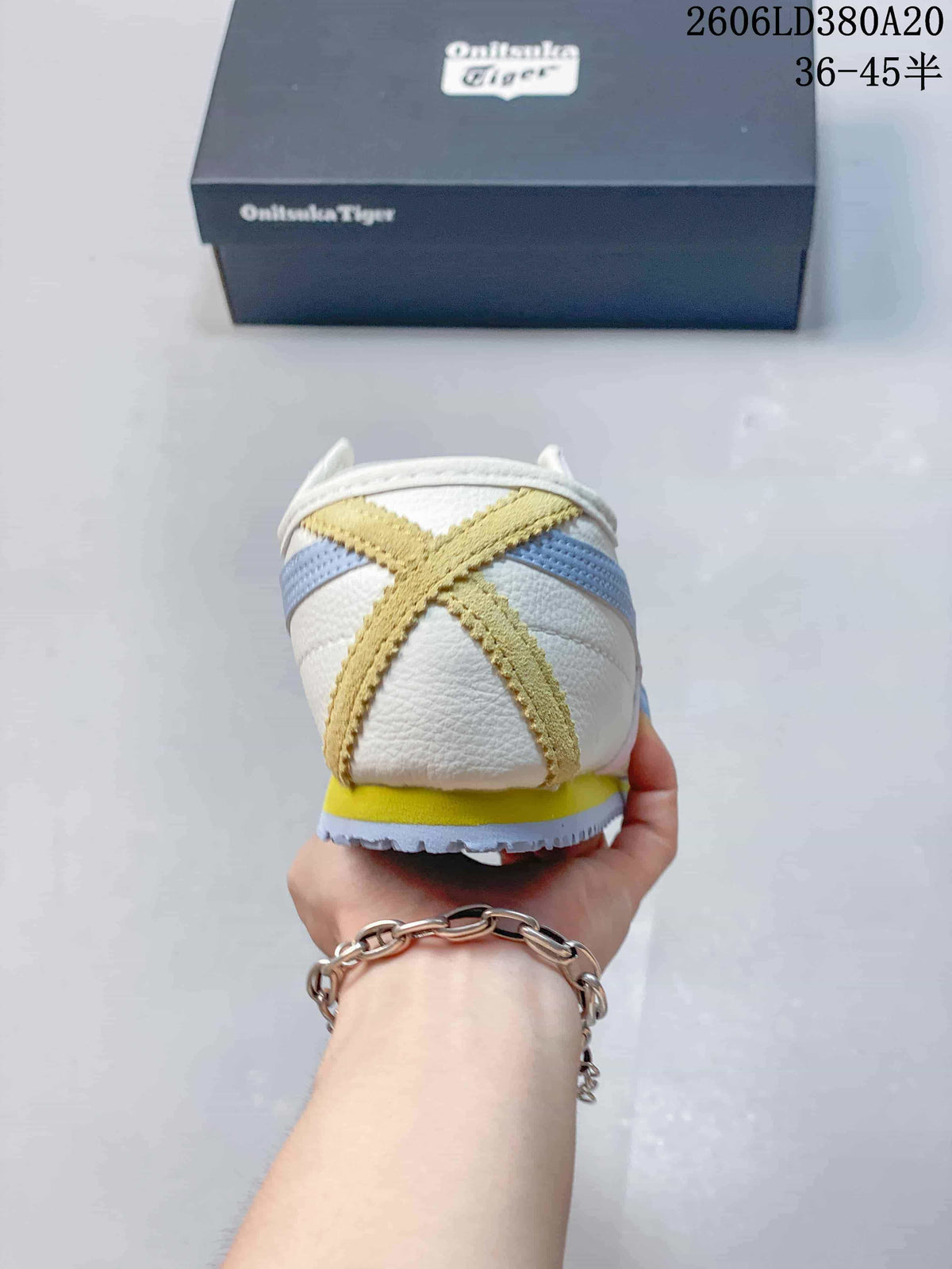 Rear view showing the sneaker's heel accents in yellow, light blue, and white.