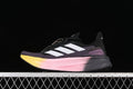 Side view of black Adidas Ultraboost 5X shoes with white stripes and a pink-to-yellow gradient midsole.