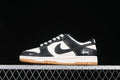 Side view of black and white low-top sneakers with patterned laces, heel script, and gum-colored outsole