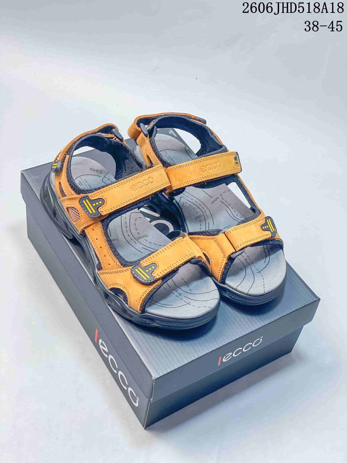 Pair of orange and gray open-toe sandals with adjustable straps, shown on a branded box.
