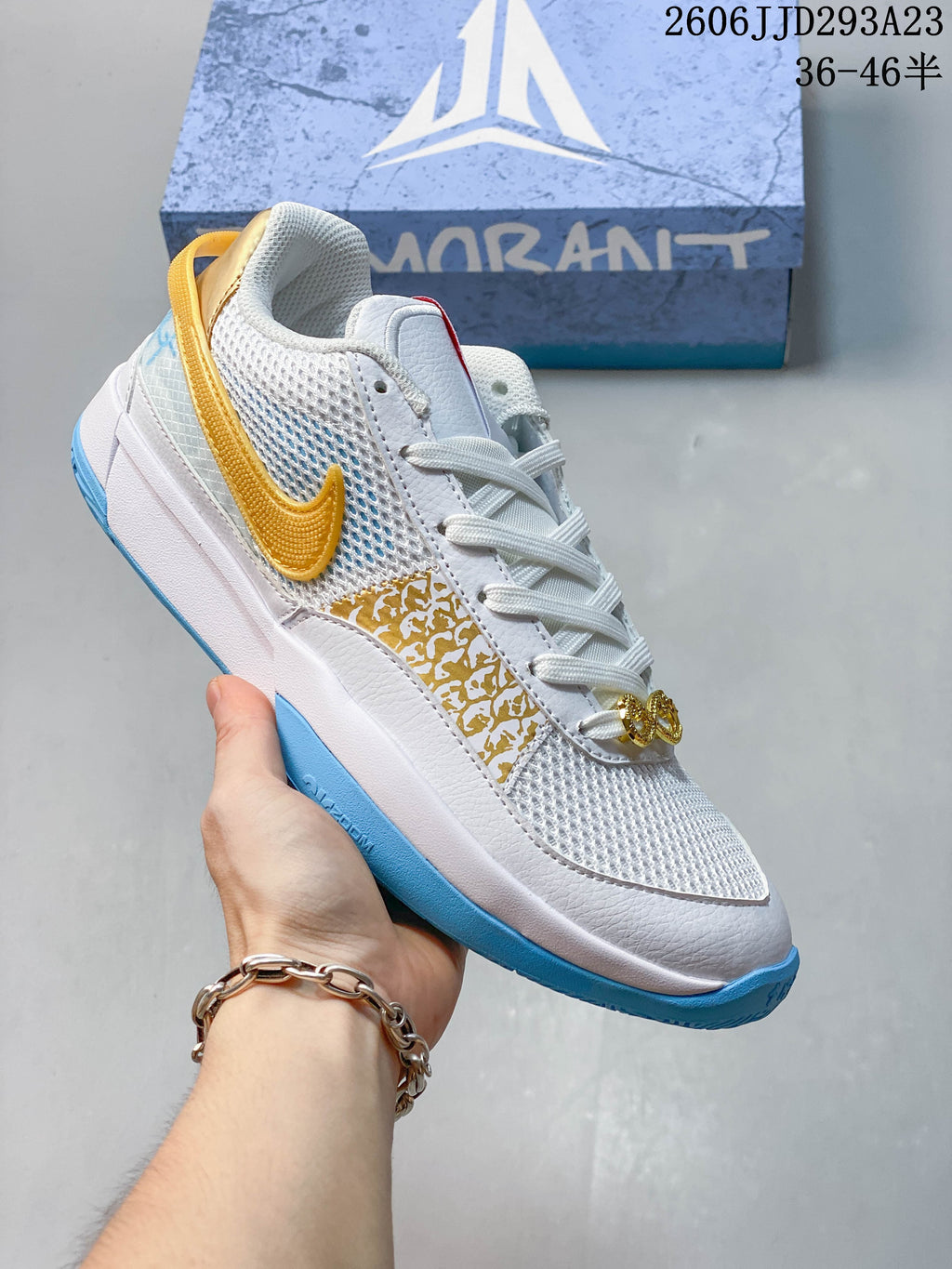 White Nike Ja 1 EP shoe with gold-colored logo and light blue outsole accents.