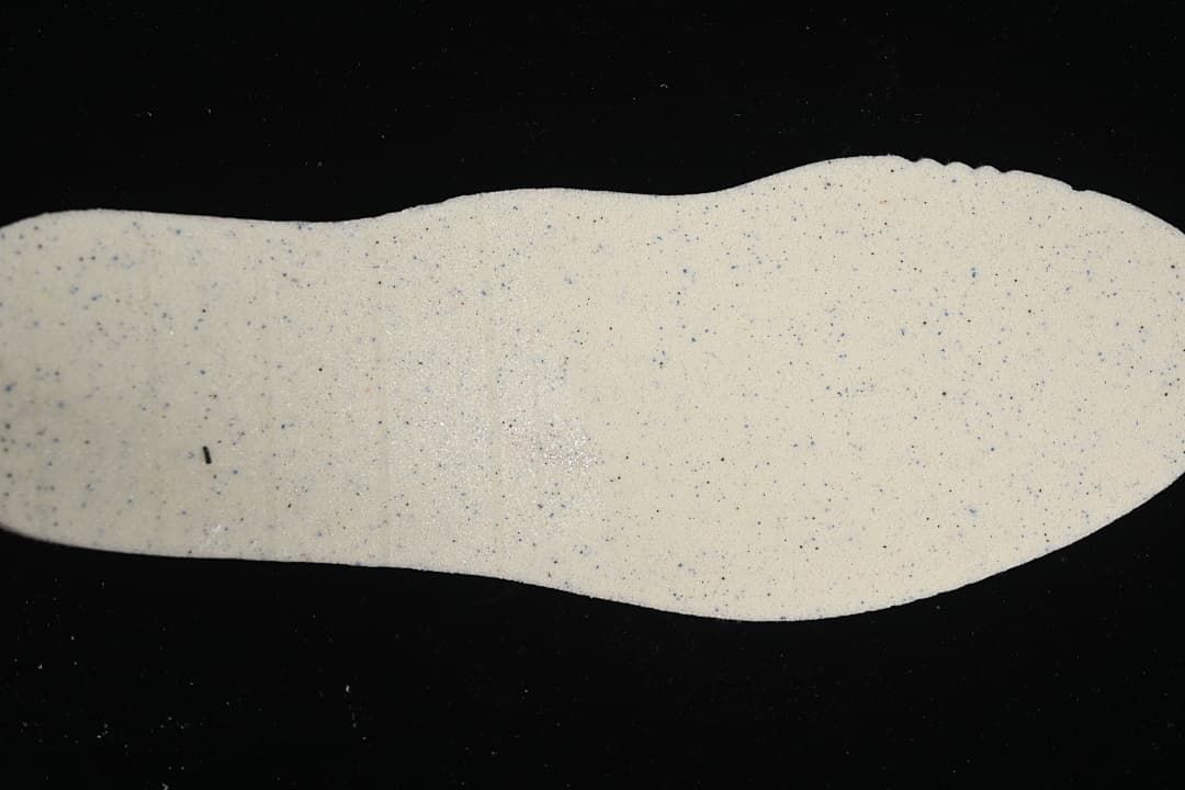 Light-colored textured shoe insert shown on a dark background
