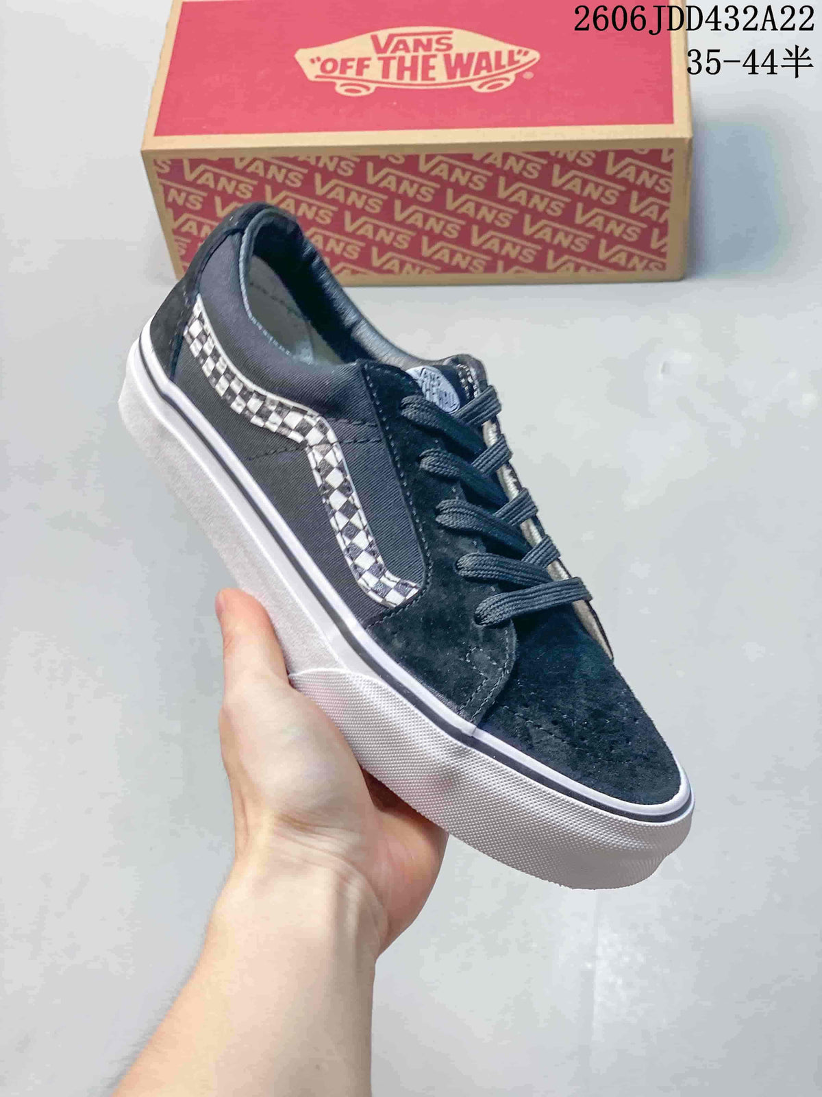 Angled view of a black Vans low-top sneaker with checkerboard side stripe