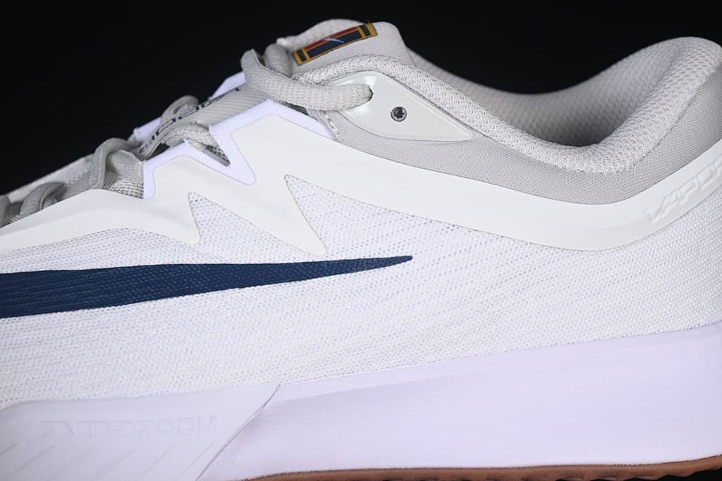 Close-up of the white and navy side panels and mesh-look upper.