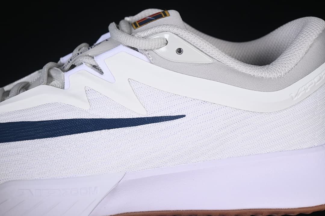 Close-up of the white and navy side panels and mesh-look upper.