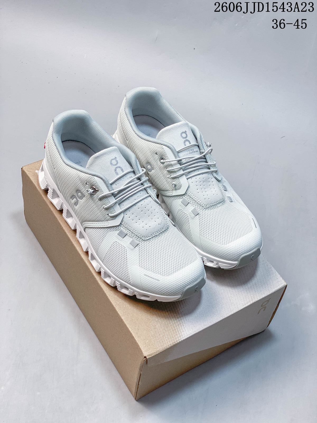 Pair of light-colored On Cloudtilt Remix sneakers on a shoebox