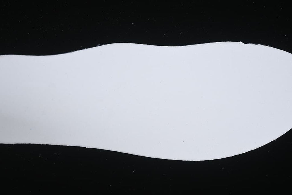 White shoe-shaped insert photographed against a black background.