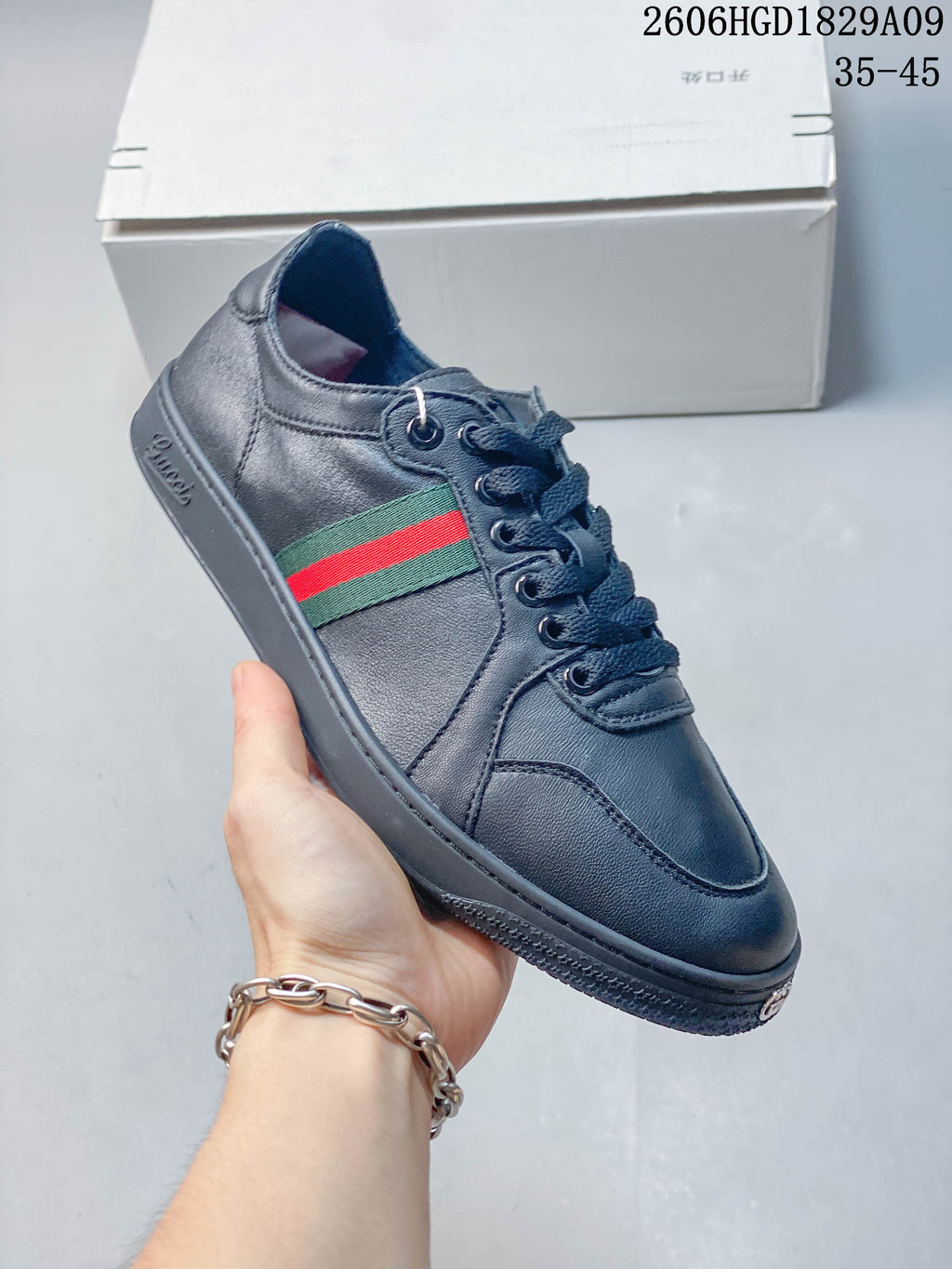 Angled side view of a navy sneaker with green-and-red stripes and tonal sole.