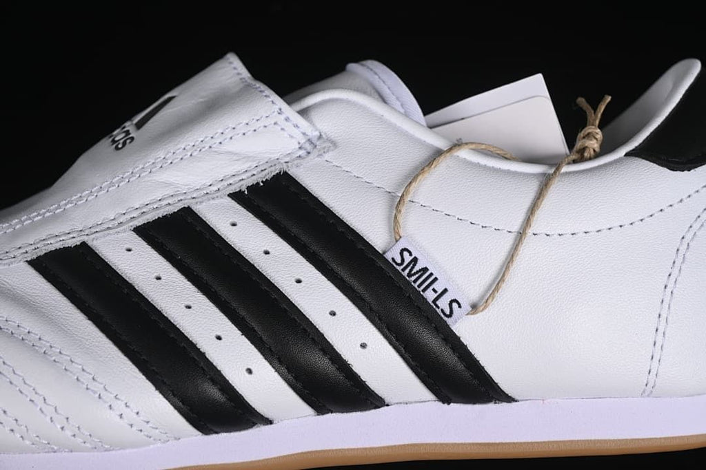 Close-up of the broad instep strap, black side stripes, and stitched upper.