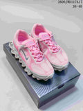 Pair of pink, white, and gray Nike Air Liquid Max low-top sneakers on a shoebox
