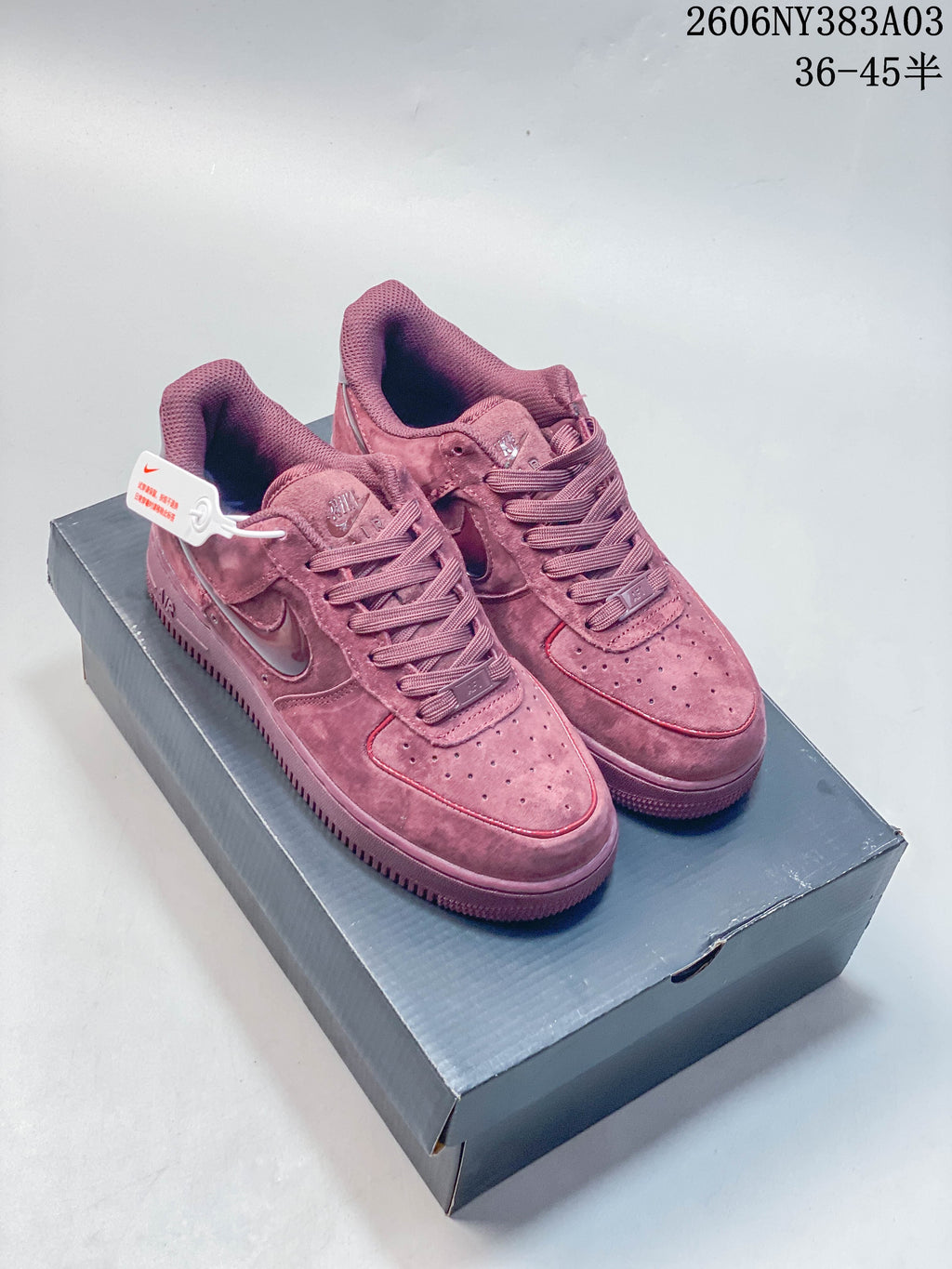 Pair of dusty rose Nike Air Force 1 low-top sneakers displayed on a shoebox