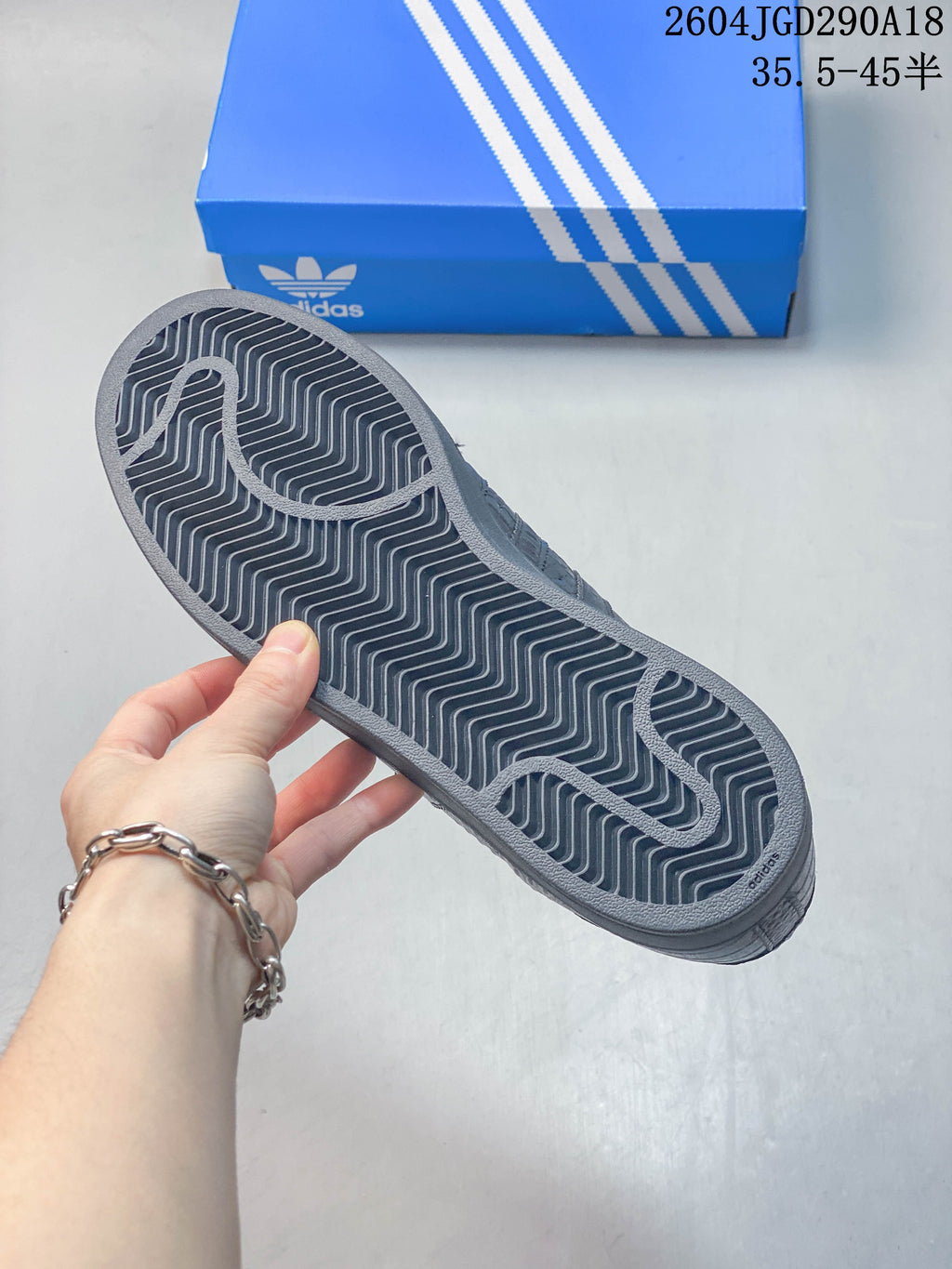 Underside of the dark outsole showing a repeating zigzag tread pattern.