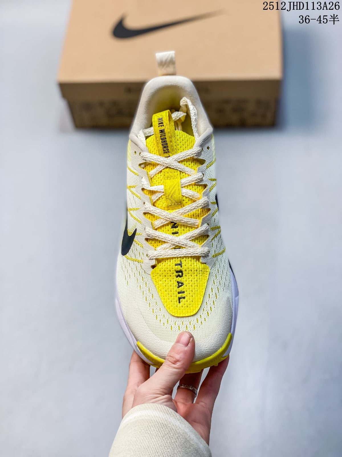 Top view of the Nike Wildhorse trail shoe showing its laces, bright yellow tongue details, and off-white upper; image overlay states sizes 36–45.5.