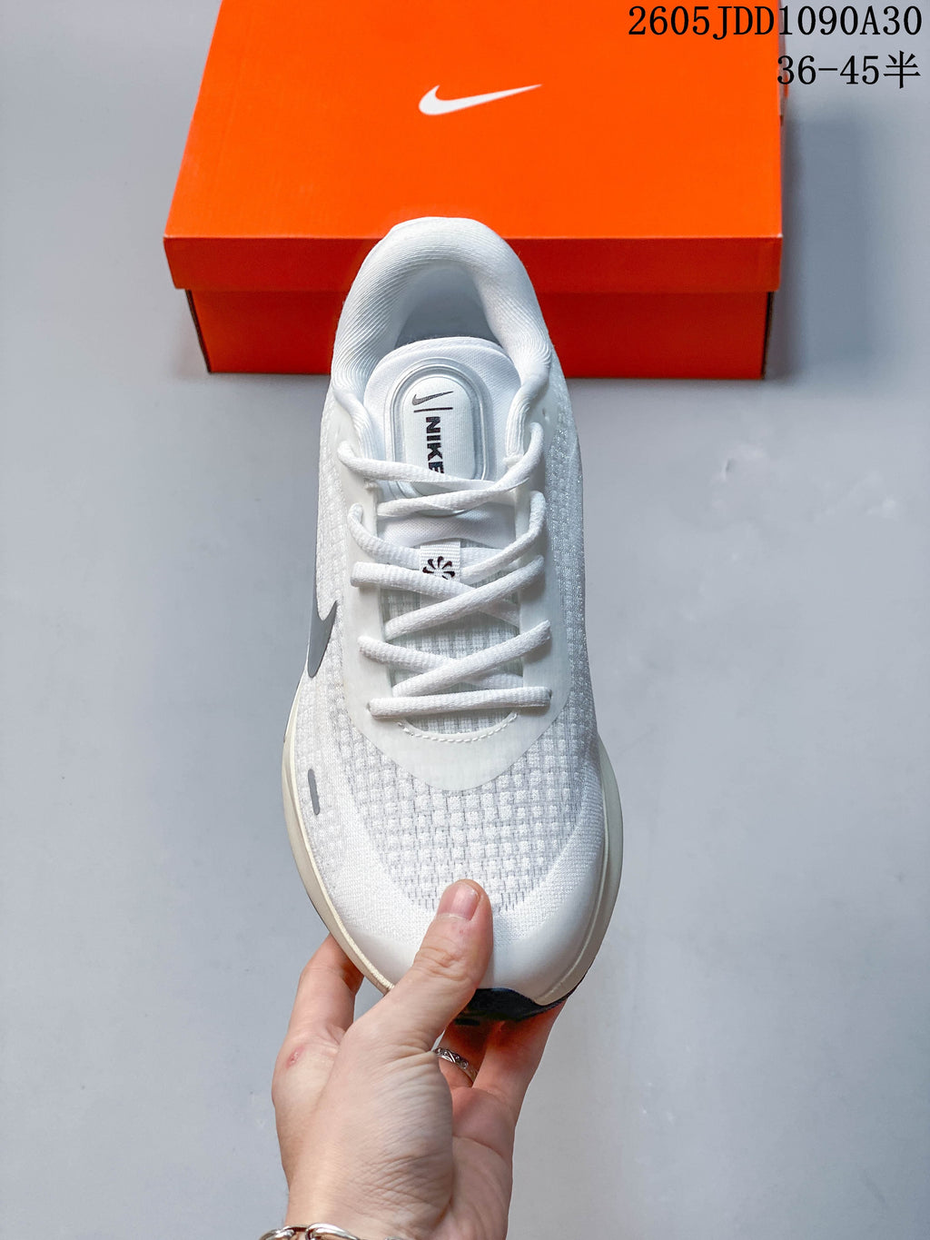 Top view of a white Nike Journey Run shoe showing its laces and textured upper.
