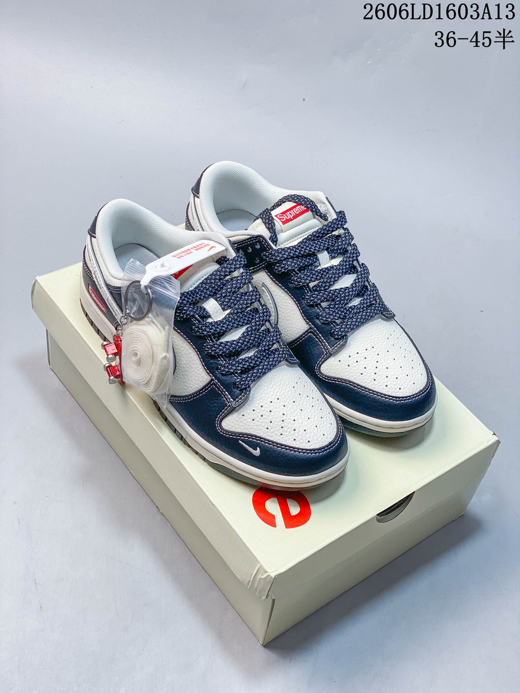 Pair of white and navy low-top sneakers with dark laces and an extra lace set