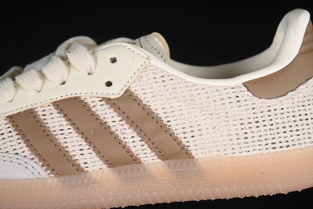 Close-up of beige laces, brown side stripes, and textured upper