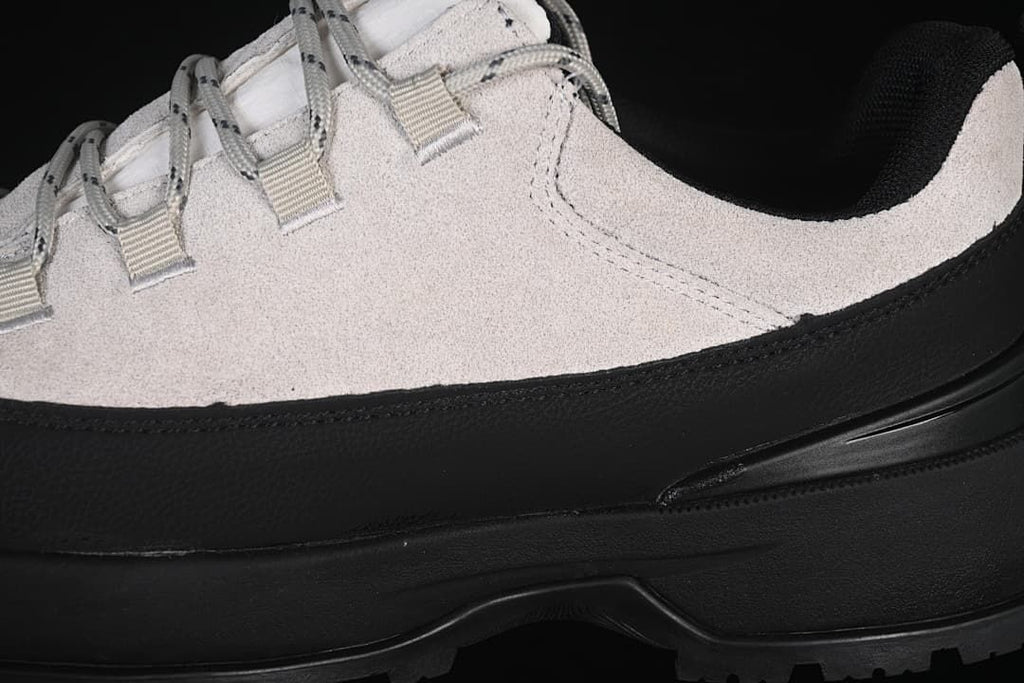 Close-up of light grey upper, black side overlay and sole