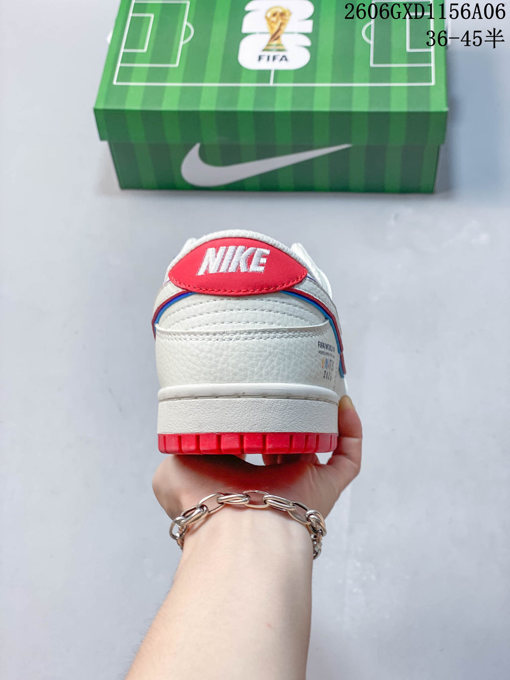 Rear view of the sneaker with a red heel tab, white branding, and red outsole accents.