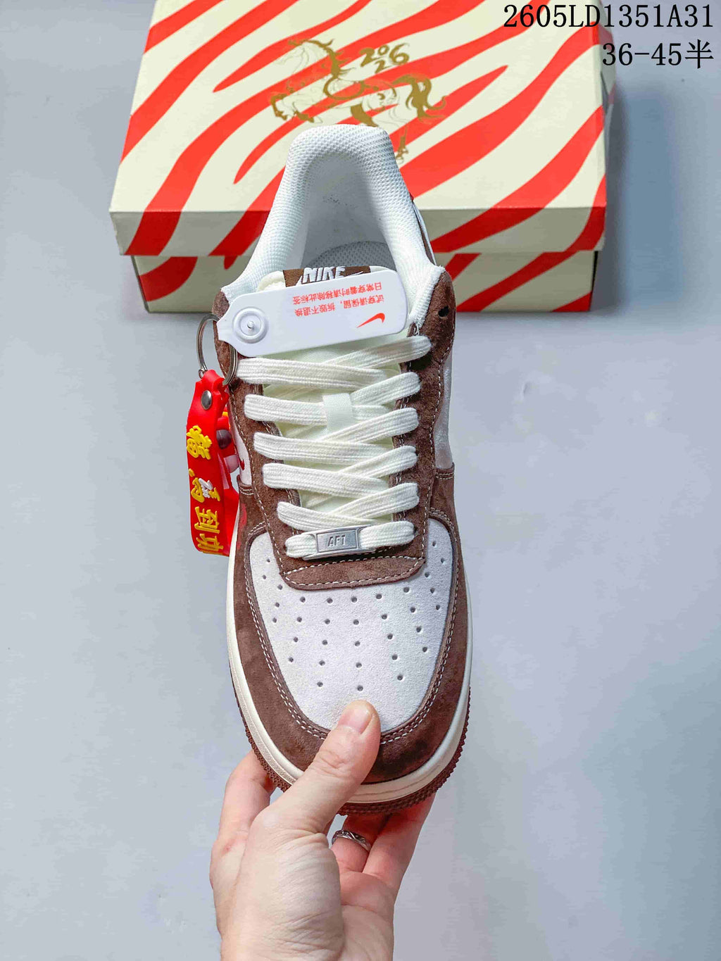 Top view showing the perforated toe, white laces, brown overlays, and decorative tag.