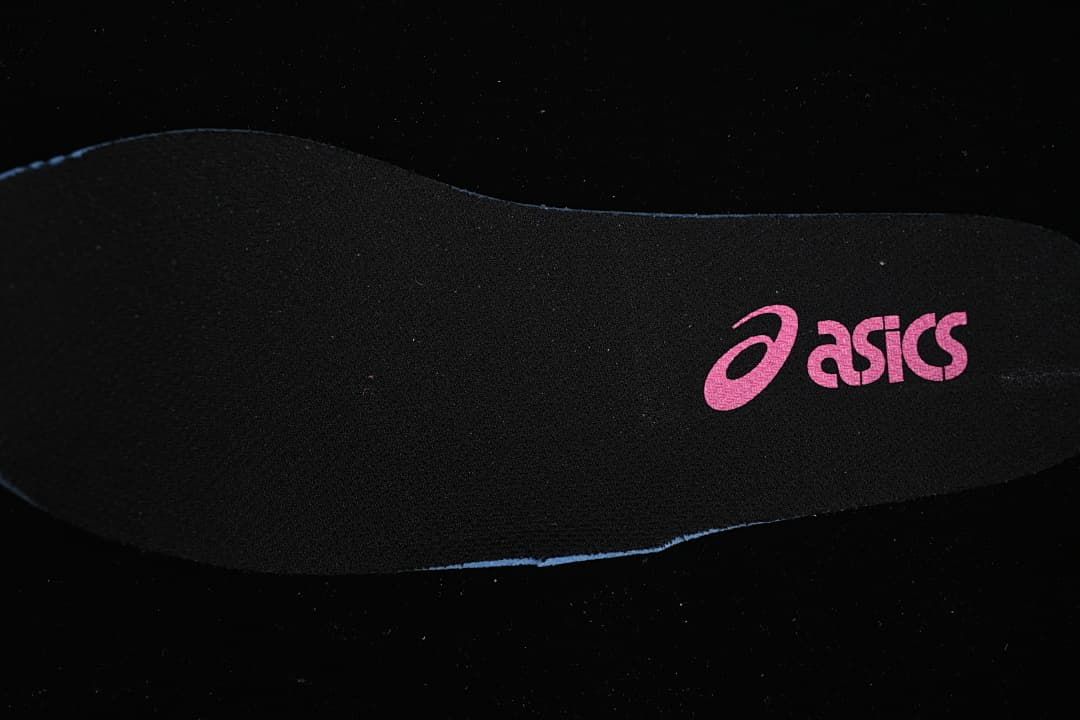 Black shoe insole with a pink ASICS logo.