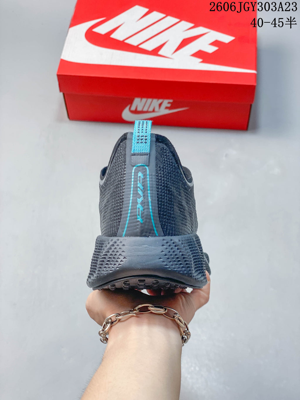 Rear view of a charcoal Nike Ava Rover shoe with blue heel accents