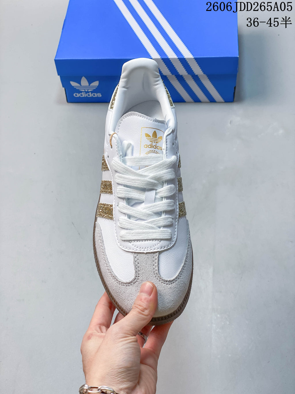 Top view of the white lace-up sneaker with gold-tone branding and glitter side accents.