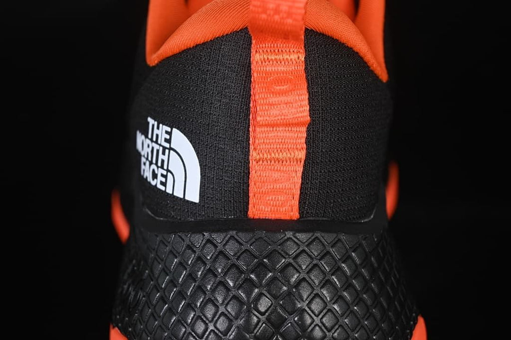 Rear view showing the orange heel pull tab and textured black heel.